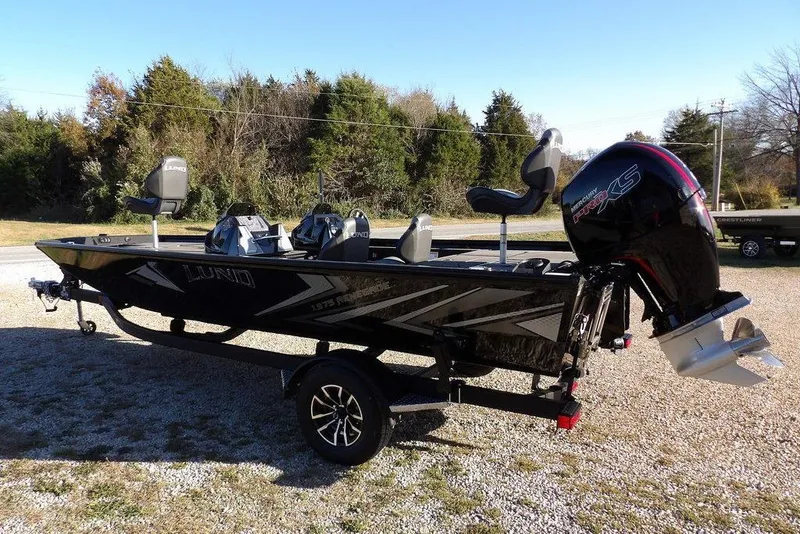 Slide: The Image of 2026 Lund 1975 Renegade fishing boat with Mercury Pro XS engine, parked outdoors. - 5