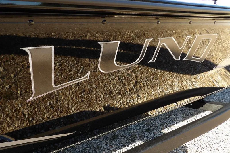 Slide: The Image of Close-up of Lund 1975 Renegade boat logo, 2026 model, on textured surface. - 52
