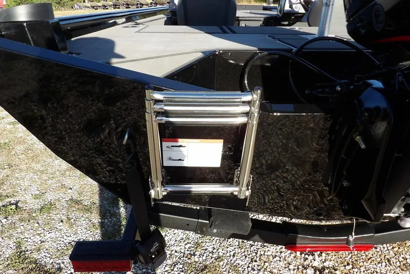 Slide: The Image of 2026 Lund 1975 Renegade boat with ladder and motor, parked on gravel. - 54