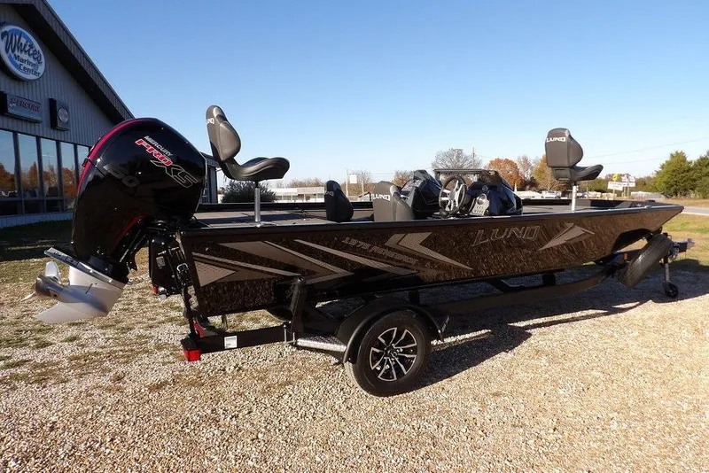 Slide: The Image of 2026 Lund 1975 Renegade boat with powerful outboard motor, parked outdoors. - 7