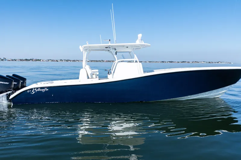 Slide: The Image of 2014 Yellowfin 36 Offshore boat on calm water, clear blue sky background. - 11