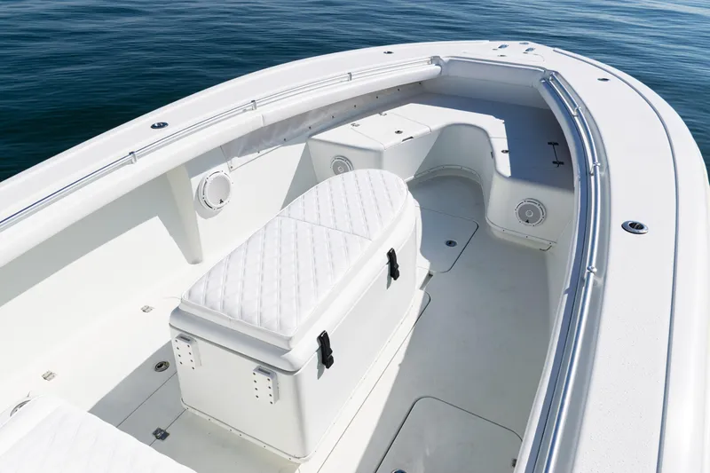 Slide: The Image of 2014 Yellowfin 36 Offshore boat interior with white seating and storage, on calm water. - 12