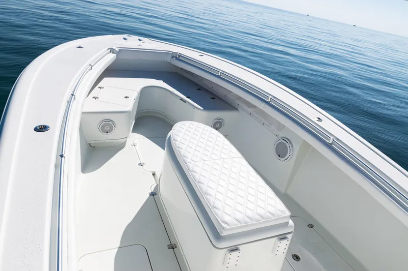 Slide: The Image of 2014 Yellowfin 36 Offshore boat interior with cushioned seating on calm water. - 13