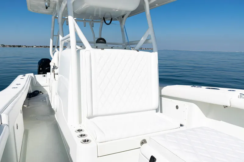 Slide: The Image of 2014 Yellowfin 36 Offshore boat interior with white seating on calm water. - 24