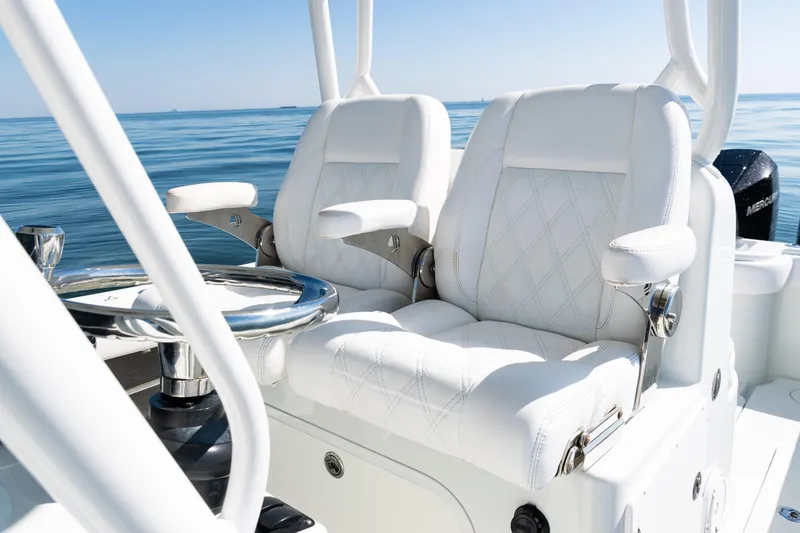 Slide: The Image of 2014 Yellowfin 36 Offshore boat with luxurious white seating and steering wheel on calm water. - 30