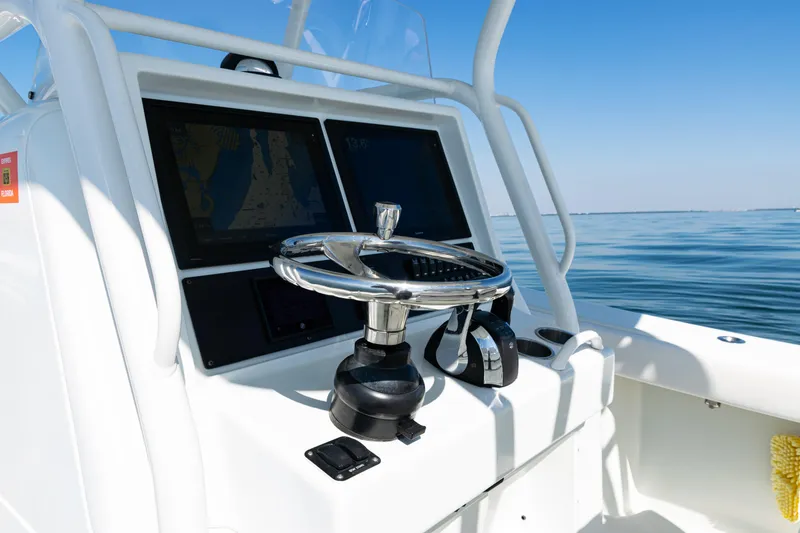 Slide: The Image of Steering console of 2014 Yellowfin 36 Offshore boat with navigation screens, on calm water. - 31
