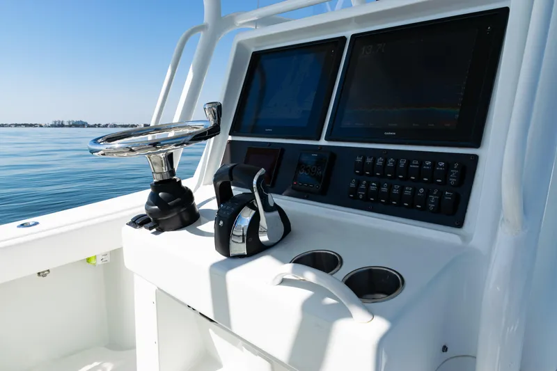 Slide: The Image of 2014 Yellowfin 36 Offshore boat dashboard with steering wheel and navigation screens. - 32