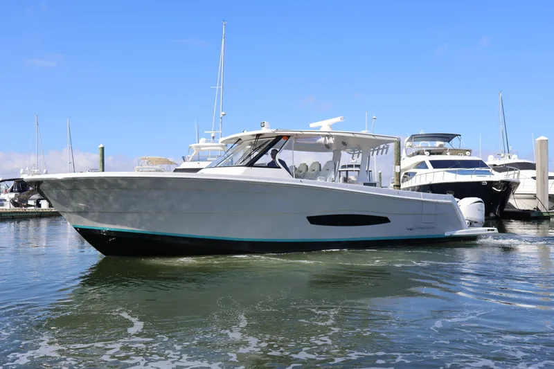 Slide: The Image of 2022 Regal 38 SAV boat docked in marina, clear sky background. - 11