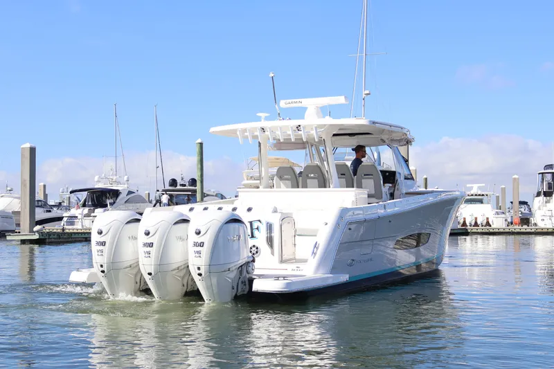 Slide: The Image of 2022 Regal 38 SAV boat with triple Yamaha engines docked in marina. - 12