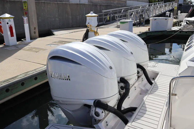 Slide: The Image of 2022 Regal 38 SAV boat with triple Yamaha outboard engines docked at marina. - 16
