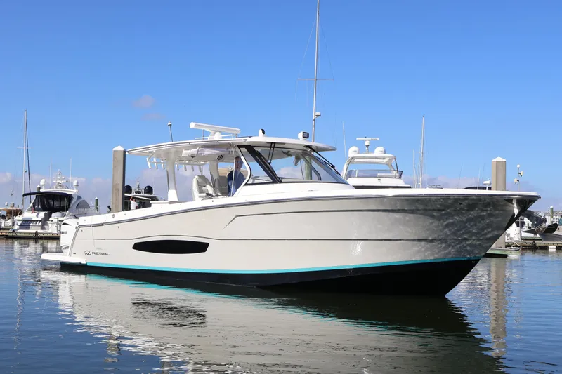Slide: The Image of 2022 Regal 38 SAV boat docked in marina under clear blue sky. - 2