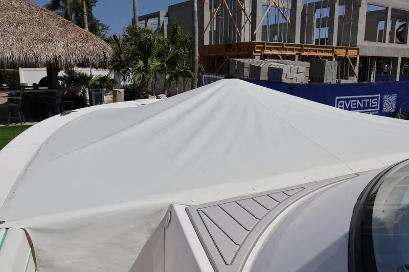 Slide: The Image of 2022 Regal 38 SAV boat with protective cover, construction site in background. - 21