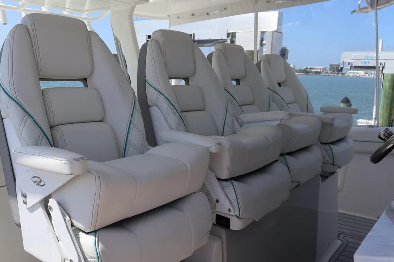 Slide: The Image of Luxury seating on 2022 Regal 38 SAV boat, featuring plush white leather chairs. - 53