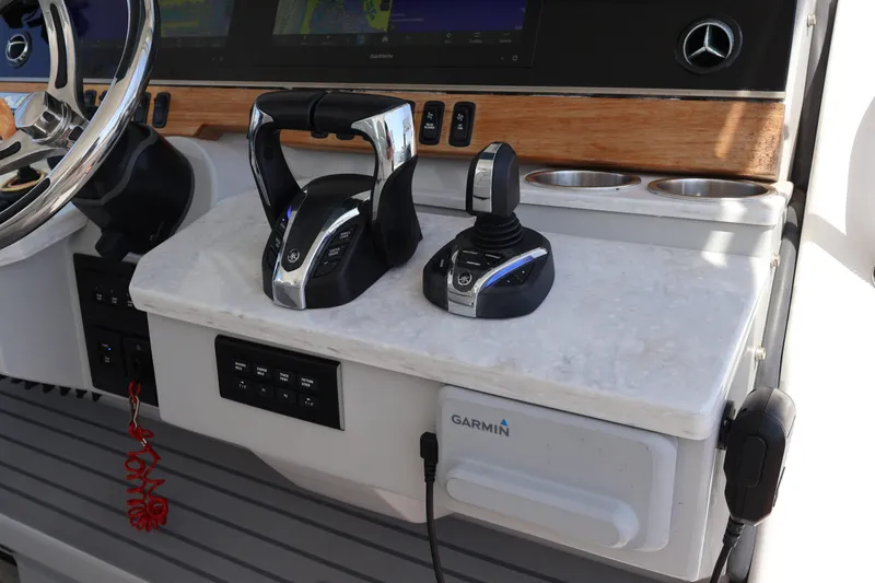 Slide: The Image of 2022 Regal 38 SAV helm with controls, steering wheel, and Garmin navigation system. - 65