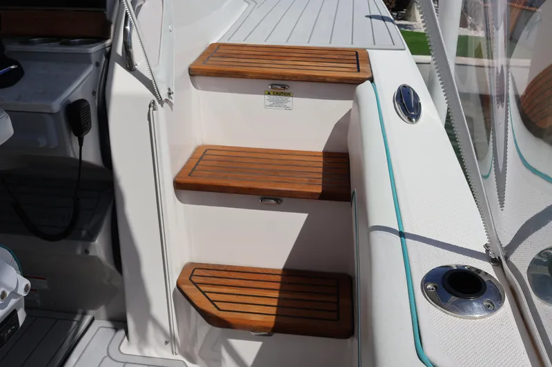 Slide: The Image of Wooden steps on a 2022 Regal 38 SAV boat deck, featuring sleek design elements. - 72