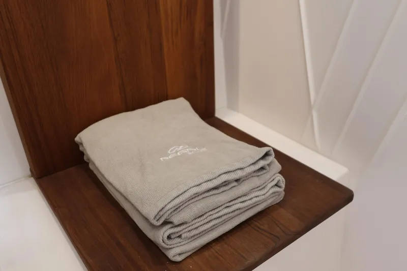 Slide: The Image of Folded gray towel on wooden shelf in 2022 Regal 38 SAV boat interior. - 85