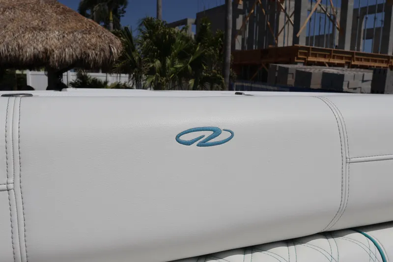 Slide: The Image of 2022 Regal 38 SAV boat seat with logo, white upholstery, outdoor setting. - 91