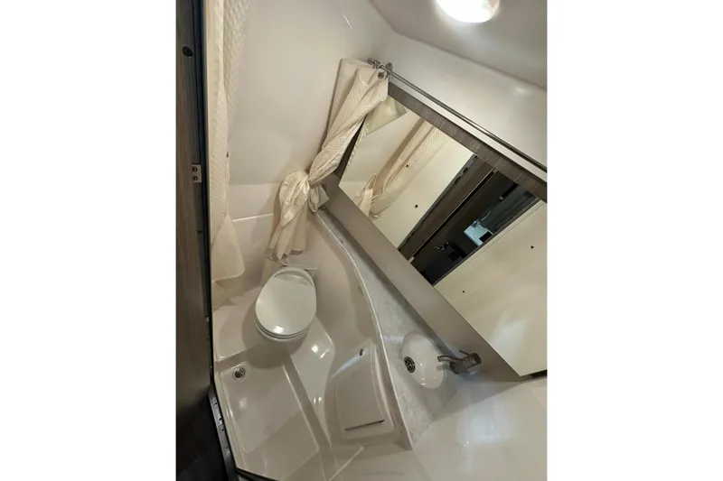 Slide: The Image of 2022 Regal 28 Express bathroom with toilet, sink, and mirror. - 17