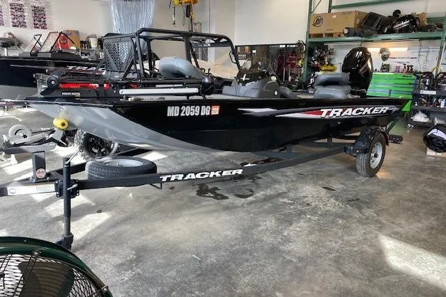 The Image of 2025 Tracker Pro 170 boat in garage, featuring a black exterior and Mercury outboard motor. - 0