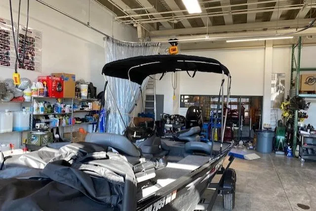 Slide: The Image of 2025 Tracker Pro 170 boat in a workshop, featuring a black canopy and organized tools. - 7