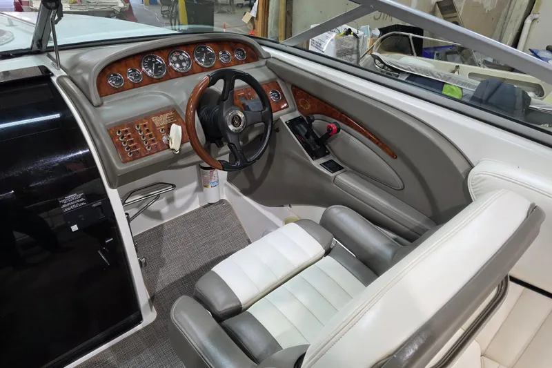 Slide: The Image of Interior of a 2001 Cobalt 263 boat with wood-accented dashboard and leather seating. - 10