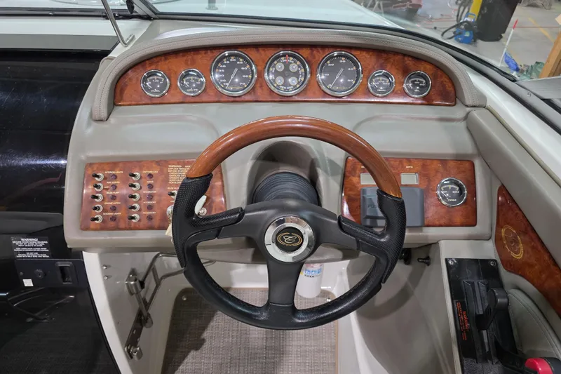 Slide: The Image of Dashboard of a 2001 Cobalt 263 boat with wood accents and steering wheel. - 12