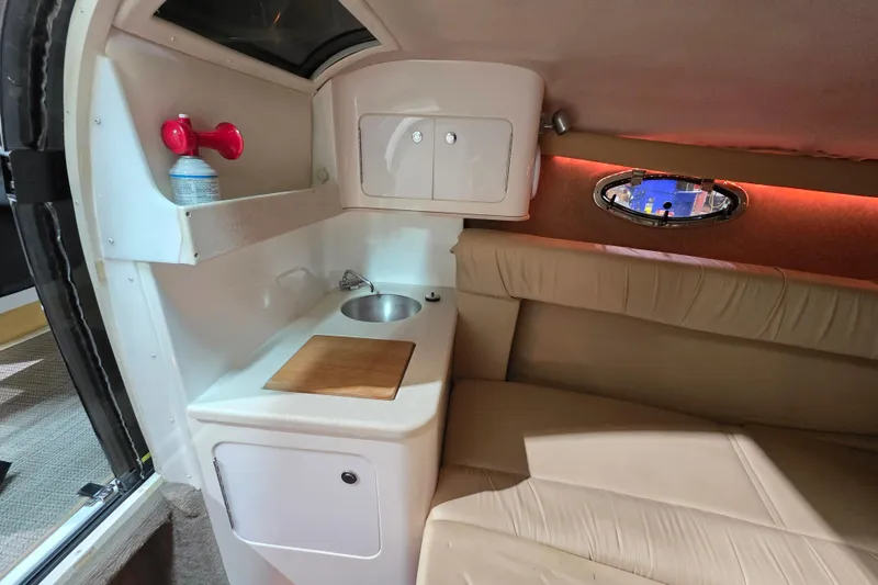 Slide: The Image of 2001 Cobalt 263 boat interior with kitchenette, sink, and seating area. - 16