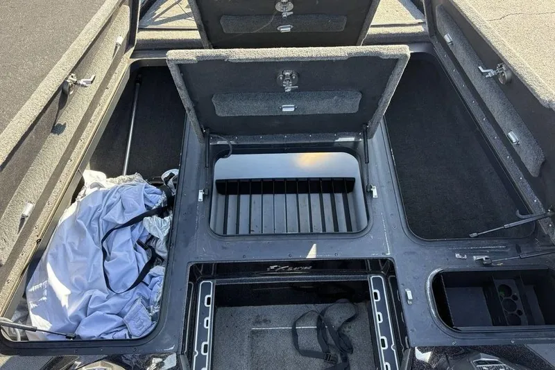 Slide: The Image of 2015 Skeeter FX20 boat storage compartments with open hatches and gear inside. - 15