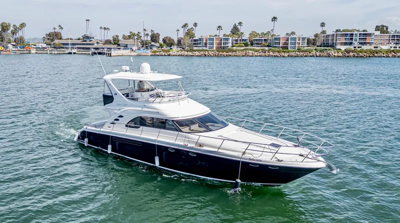 The Image of 2002 Sea Ray 560 Sedan Bridge yacht cruising in a scenic harbor. - 0