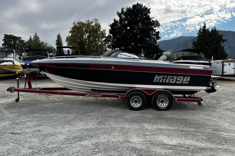 Slide: The Image of 1988 Mirage Manufacturing 217 Intruder boat on trailer, parked outdoors under cloudy sky. - 3