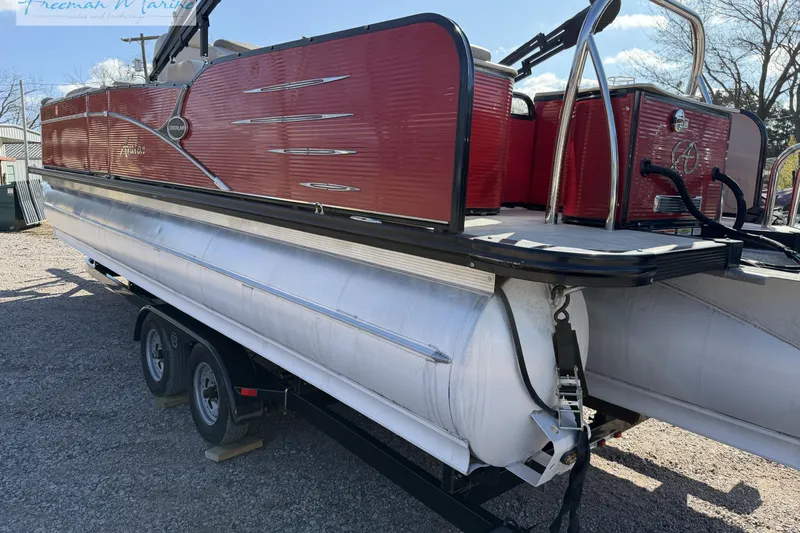 Slide: The Image of 2019 Avalon Catalina Quad Lounge 25' pontoon boat on trailer, red and silver design. - 11