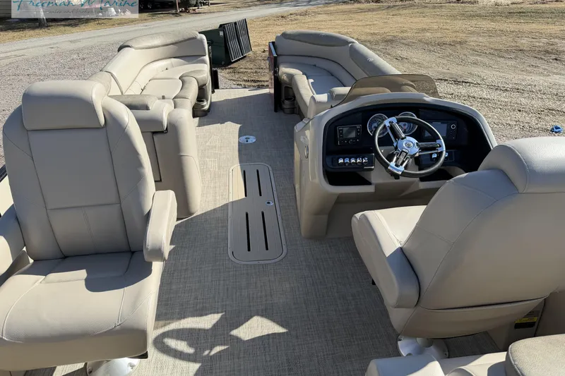 Slide: The Image of 2019 Avalon Catalina Quad Lounge 25' interior with beige seating and steering console. - 18