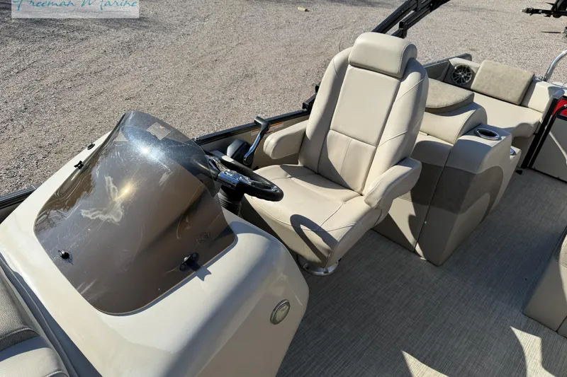 Slide: The Image of 2019 Avalon Catalina Quad Lounge boat interior with beige seating and steering console. - 33