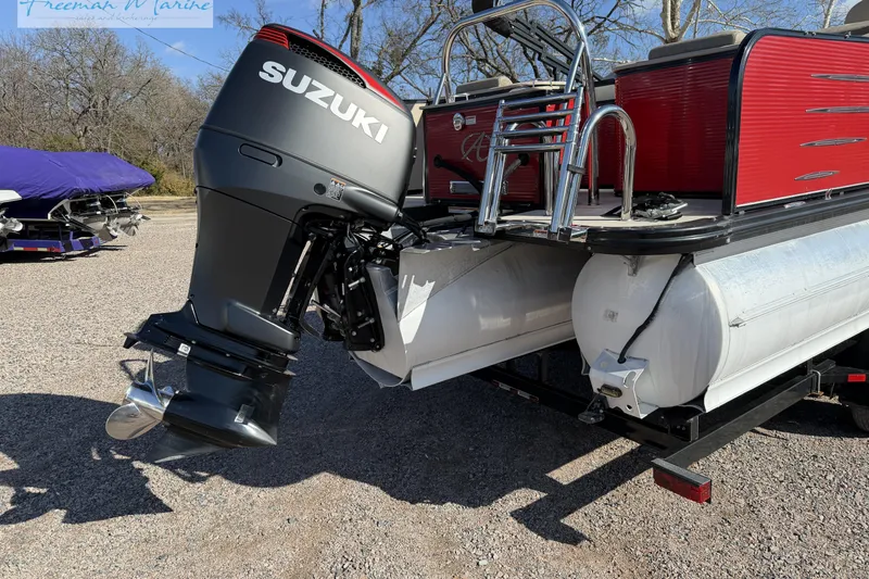 Slide: The Image of 2019 Avalon Catalina Quad Lounge 25' with Suzuki outboard motor, parked on gravel. - 6