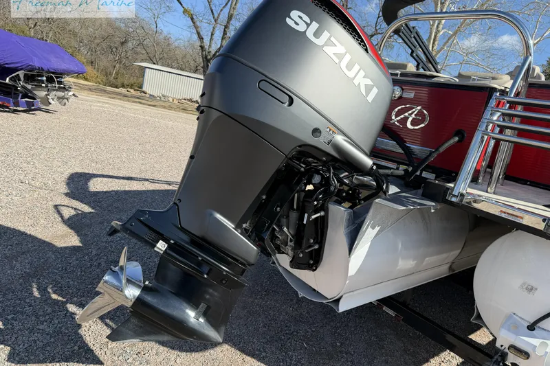 Slide: The Image of 2019 Avalon Catalina Quad Lounge 25' with Suzuki outboard motor in a parking area. - 9