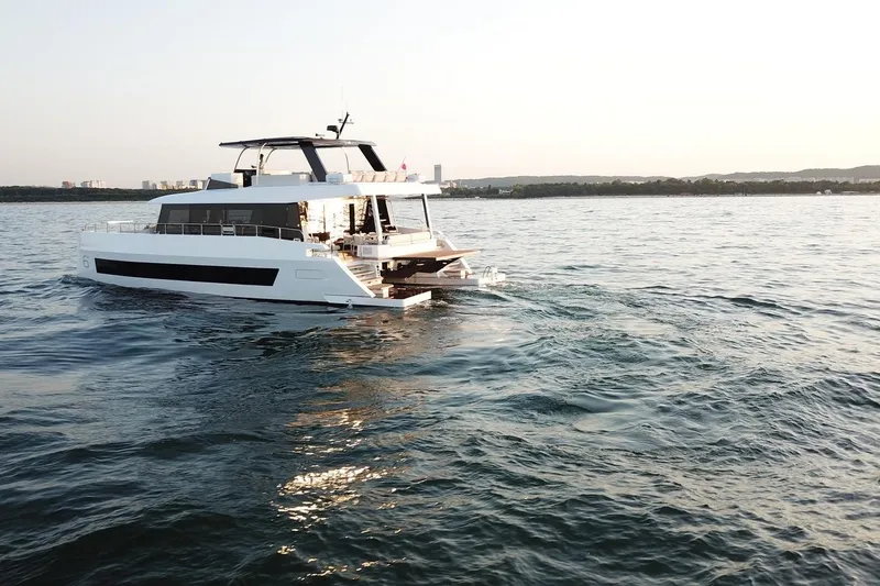 Slide: The Image of Luxury Moon Yachts 6ty 2026 cruising on serene ocean waters at sunset. - 21