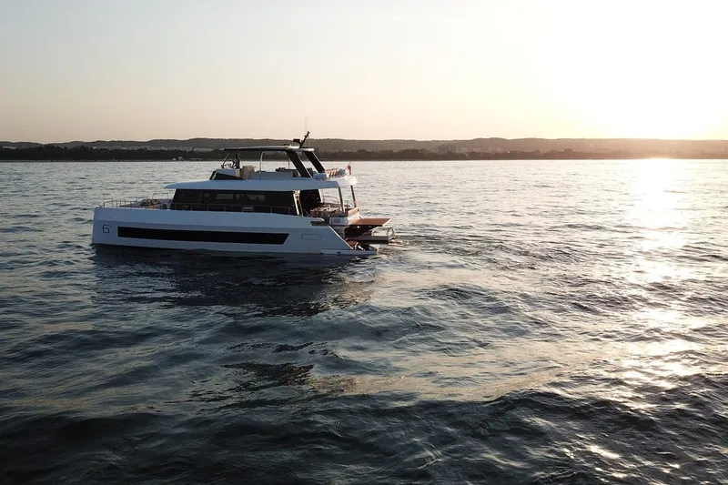 Slide: The Image of 2026 Moon Yachts 6ty sailing at sunset on calm waters. - 6