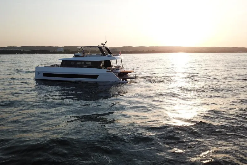 Slide: The Image of 2026 Moon Yachts 6ty sailing at sunset on calm waters. - 35