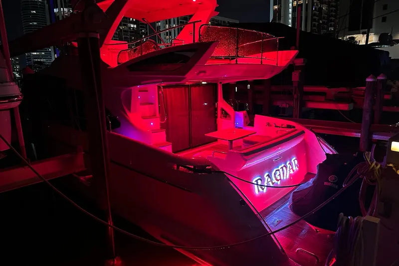 Slide: The Image of Red-lit 2013 Azimut Fly 53 yacht docked at night, featuring illuminated name "Ragnar." - 10