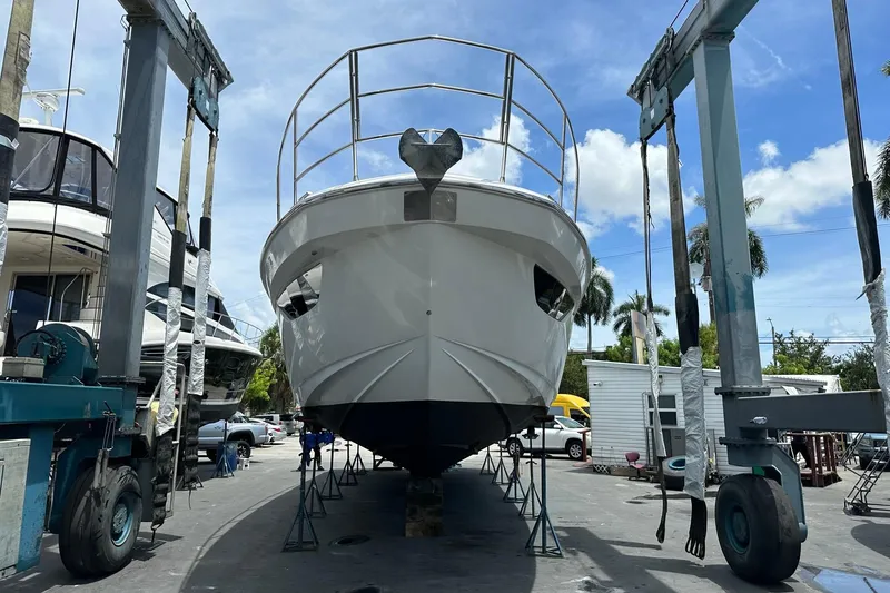 Slide: The Image of 2013 Azimut Fly 53 yacht in dry dock, undergoing maintenance under a clear blue sky. - 39