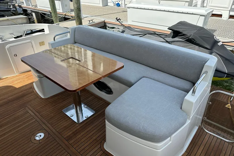 Slide: The Image of Luxury seating area on 2013 Azimut Fly 53 yacht with wooden table and cushioned bench. - 55