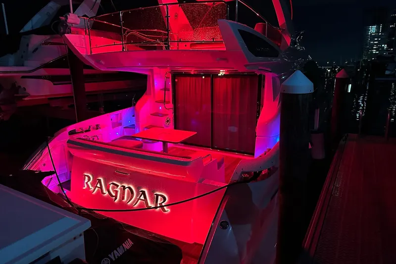 Slide: The Image of Azimut Fly 53 yacht, 2013 model, illuminated in vibrant red and blue lights at night. - 9