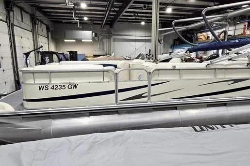 The Image of 2005 Bennington 205L pontoon boat parked outside blue garage. - 0