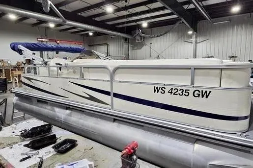 Slide: The Image of 2005 Bennington 205L pontoon boat with sleek design and blue accents. - 11