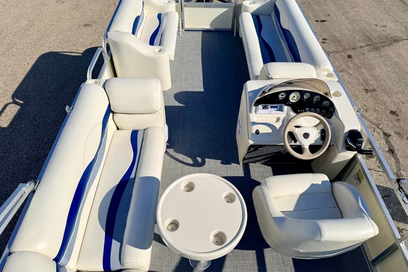 Slide: The Image of 2005 Bennington 205L pontoon boat interior with white seating and steering console. - 16