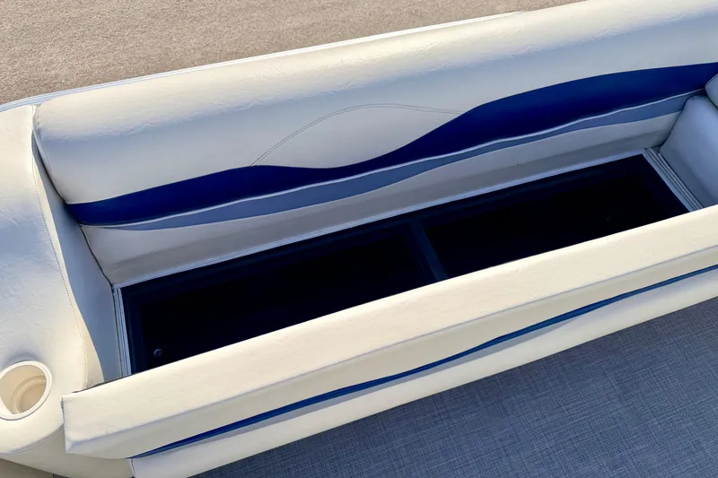 Slide: The Image of 2005 Bennington 205L boat seat with storage compartment, featuring white and blue upholstery. - 21