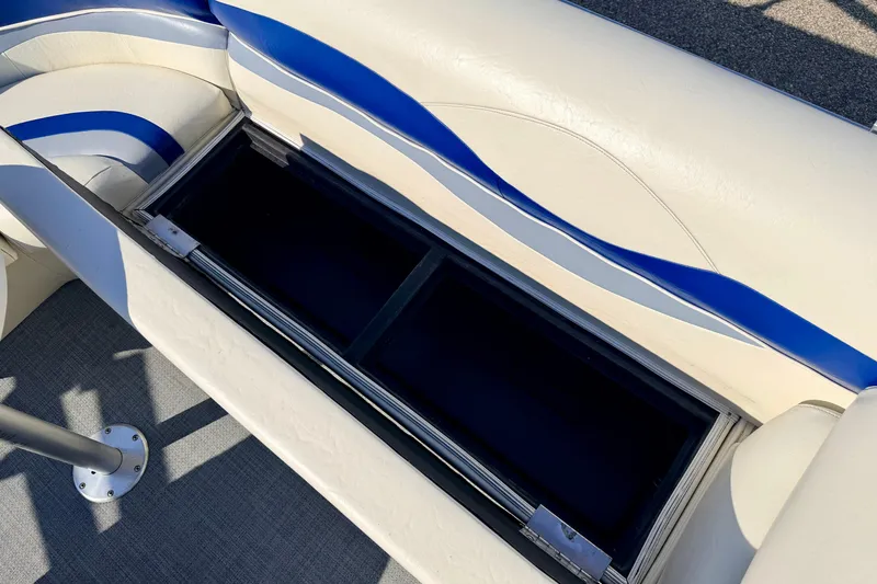 Slide: The Image of Bennington 205L 2005 boat seat storage compartment with blue and white upholstery. - 24