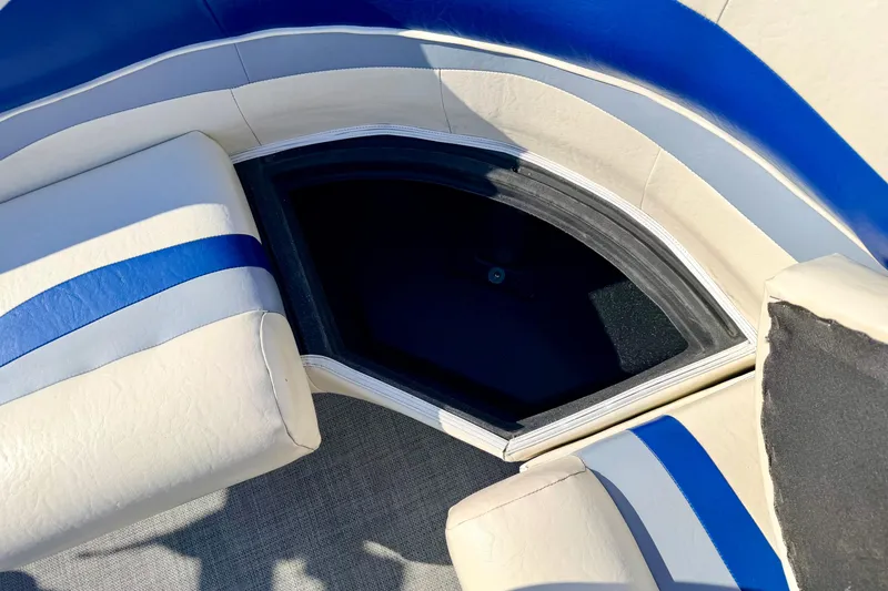 Slide: The Image of 2005 Bennington 205L boat interior with blue and white seating and storage compartment. - 26