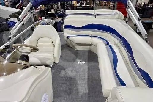 Slide: The Image of 2005 Bennington 205L pontoon boat parked near blue storage units. - 3