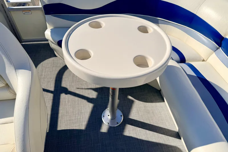 Slide: The Image of 2005 Bennington 205L boat interior with round table and cushioned seating. - 34